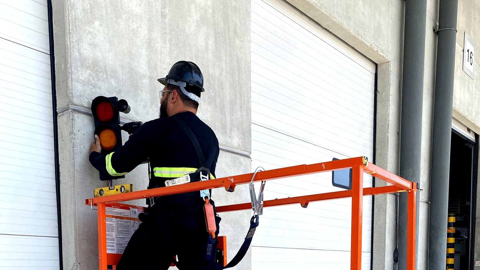 Técnico instalando sistema de semáforo em doca industrial